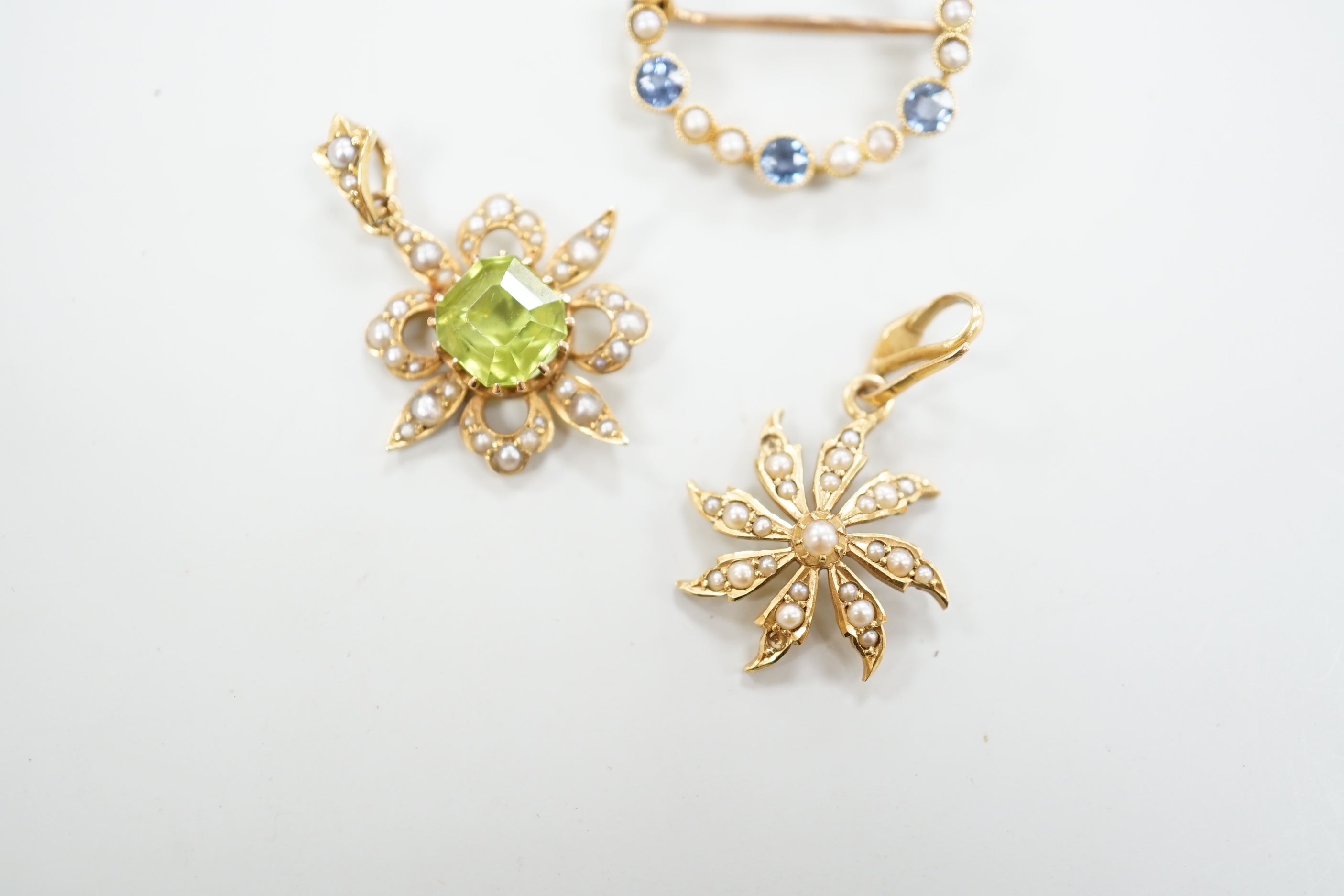 Two Edwardian 15ct and gem set pendants including peridot and seed pearl, 27mm and a similar 15ct and gem set open work circular brooch, gross weight 7 grams.